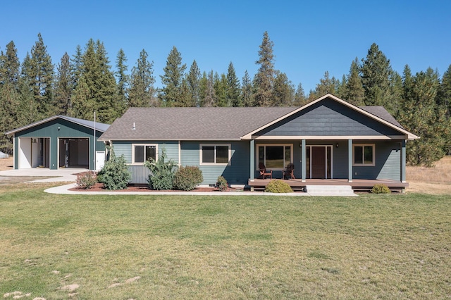 view of front of home featuring an outbuilding, a porch, a garage, and a front yard