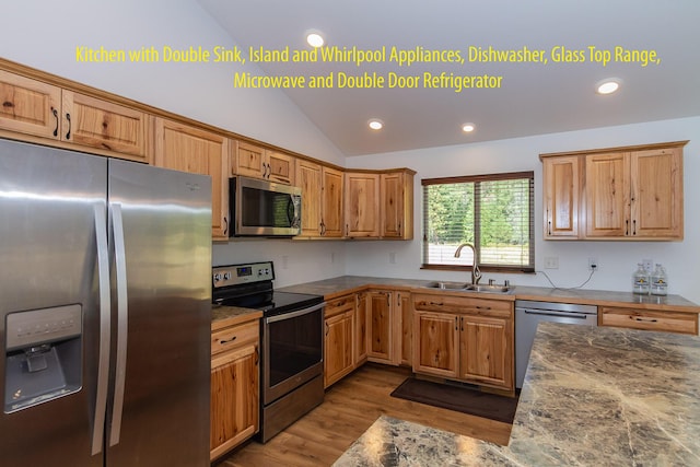 kitchen with vaulted ceiling, appliances with stainless steel finishes, sink, and light wood-type flooring