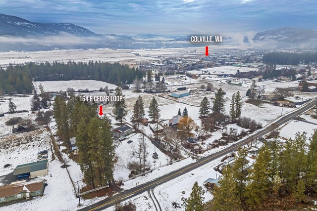 snowy aerial view with a mountain view