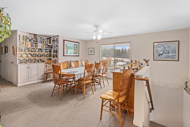 carpeted dining area featuring ceiling fan