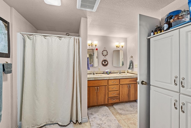 bathroom featuring vanity, curtained shower, tile patterned floors, and a textured ceiling