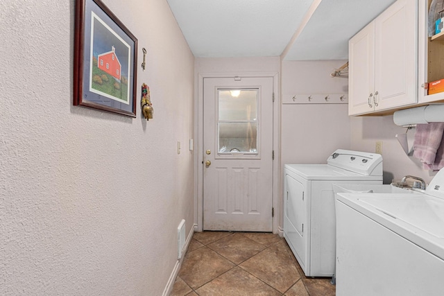 laundry room featuring washing machine and dryer, cabinets, and tile patterned flooring