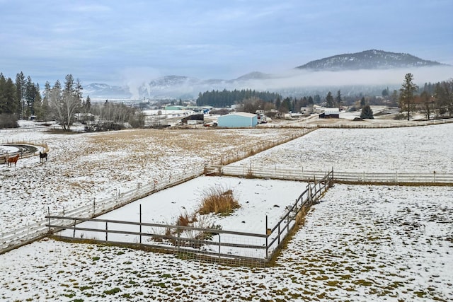 snowy yard with a mountain view and a rural view