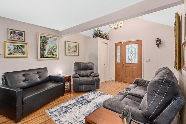 living room featuring hardwood / wood-style flooring, a chandelier, and vaulted ceiling