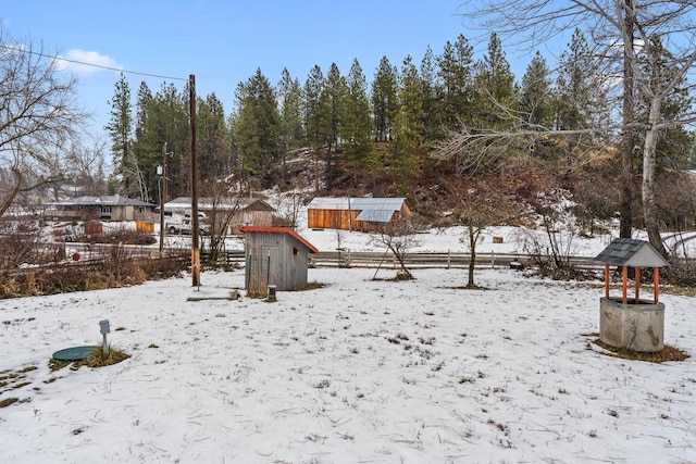 snowy yard with a storage shed