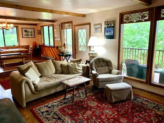 59 Bisbee Creek Ln, Kettle Falls, WA 99141 - living room featuring plenty of natural light, beamed ceiling, wood finished floors, and a chandelier
