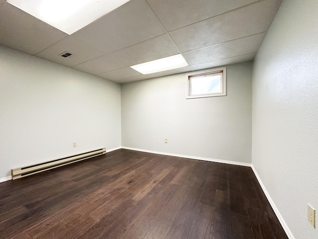 824 S Chester St, Colville, WA 99114 - basement featuring a baseboard heating unit, dark wood-style flooring, and baseboards