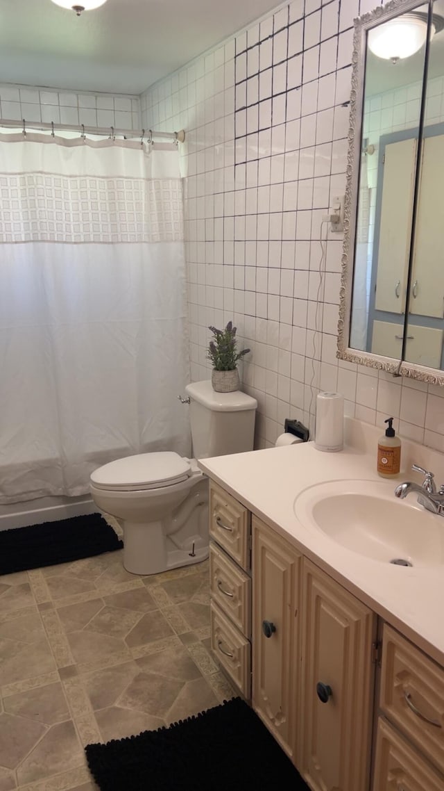 980 N Elm St, Colville, WA 99114 - bathroom with tile walls, vanity, toilet, a shower with curtain, and tasteful backsplash
