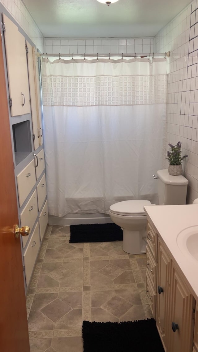 980 N Elm St, Colville, WA 99114 - full bathroom featuring toilet, vanity, curtained shower, and tile walls