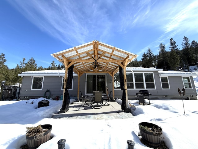 snow covered property featuring crawl space, fence, and a pergola