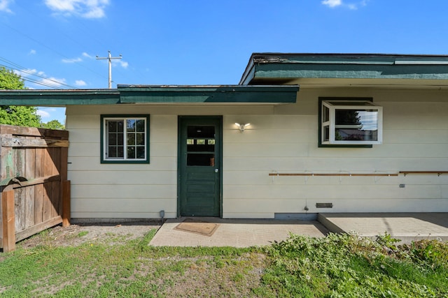 property entrance with fence and a patio