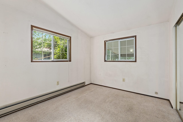 carpeted spare room with a baseboard radiator, vaulted ceiling, and baseboards