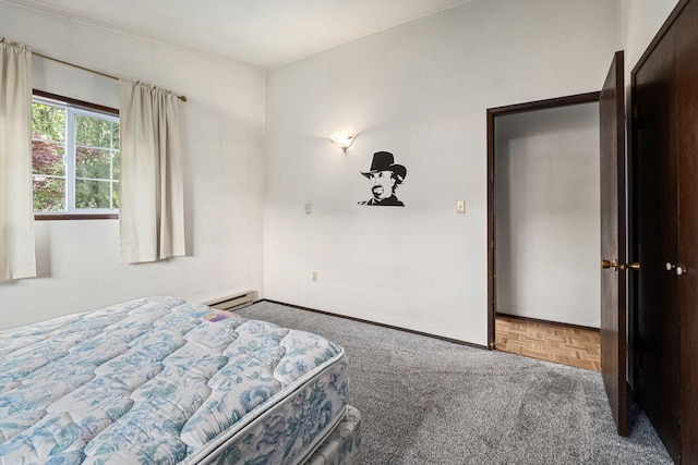 carpeted bedroom featuring baseboard heating and baseboards