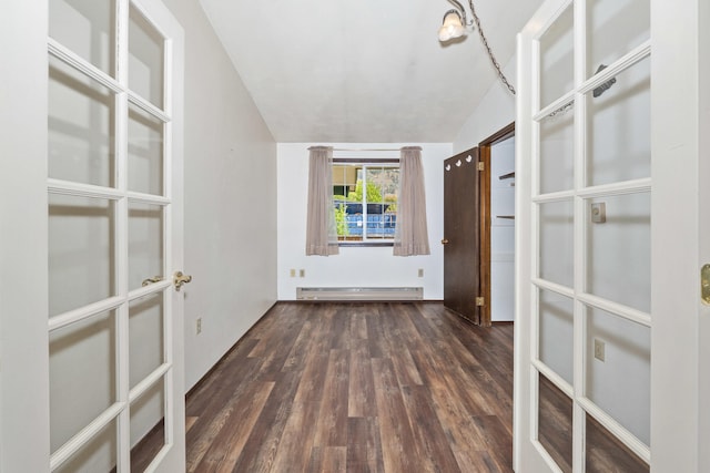 spare room with a baseboard heating unit, lofted ceiling, wood finished floors, and french doors