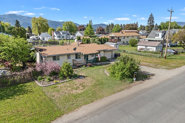 view of front of house with a residential view, a garage, driveway, and a mountain view