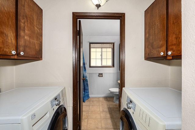 clothes washing area featuring washer and clothes dryer and wainscoting