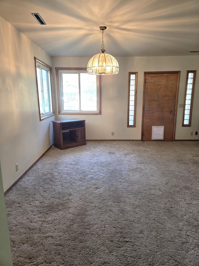 901 N 3rd St E, Chewelah, WA 99109 - carpeted spare room featuring a wealth of natural light, a notable chandelier, and visible vents