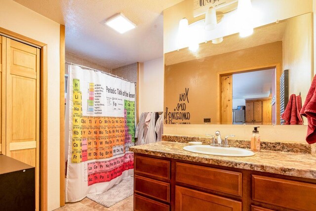 bathroom with vanity, curtained shower, and a textured ceiling