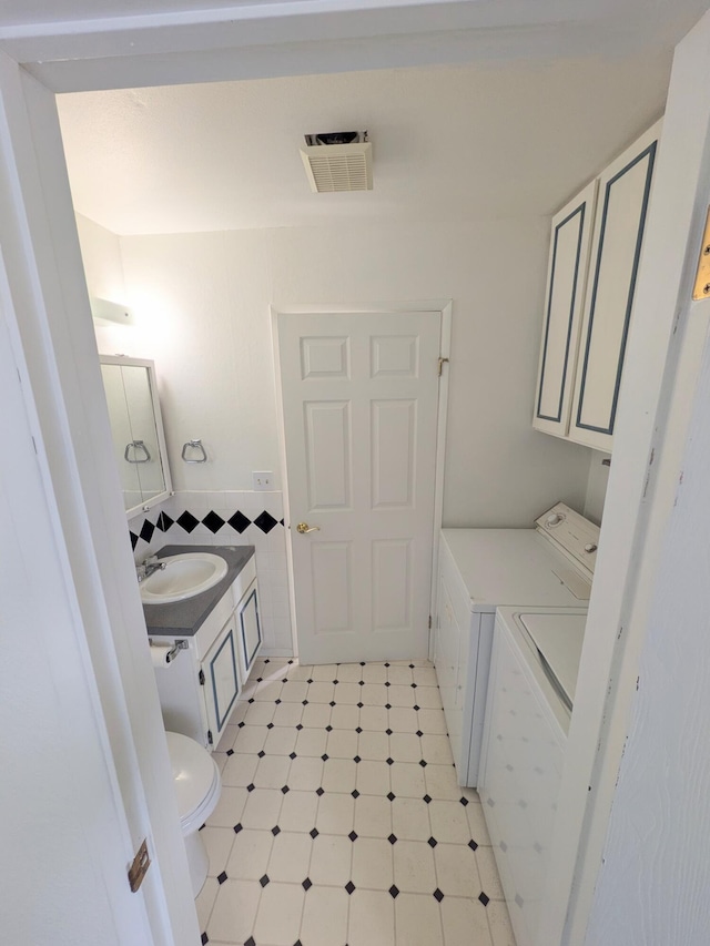 1262 E Elep Ave, Colville, WA 99114 - half bathroom featuring washer and clothes dryer, tile patterned floors, toilet, and vanity