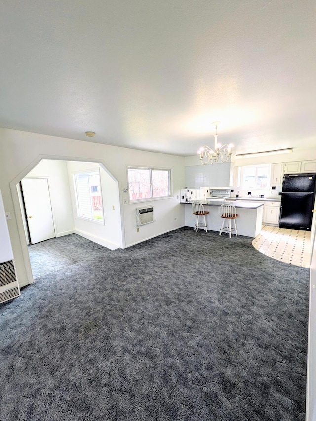 1262 E Elep Ave, Colville, WA 99114 - carpeted living area featuring a chandelier, a wall mounted air conditioner, and a heating unit