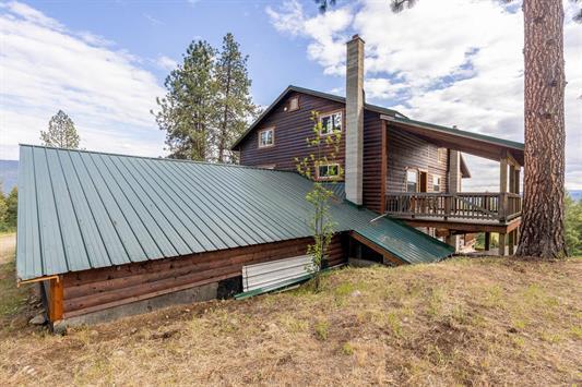 3439 Northport Flat Creek Rd Unit B, Kettle Falls, WA 99141 - view of home's exterior with a deck, metal roof, and a chimney