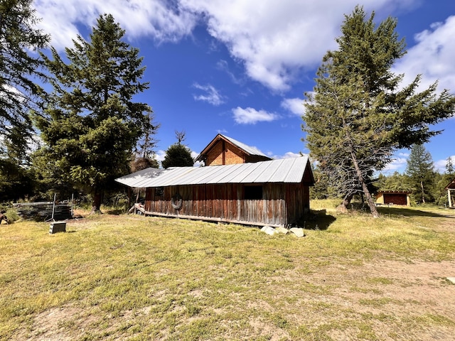 view of home's exterior featuring a yard and an outdoor structure