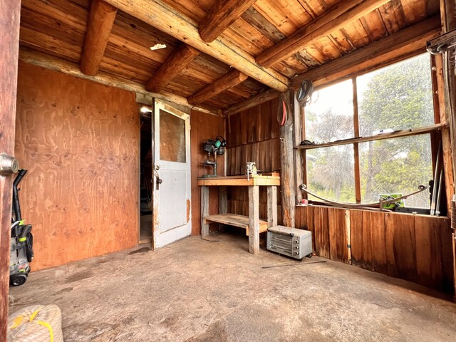 misc room featuring wooden walls and beam ceiling