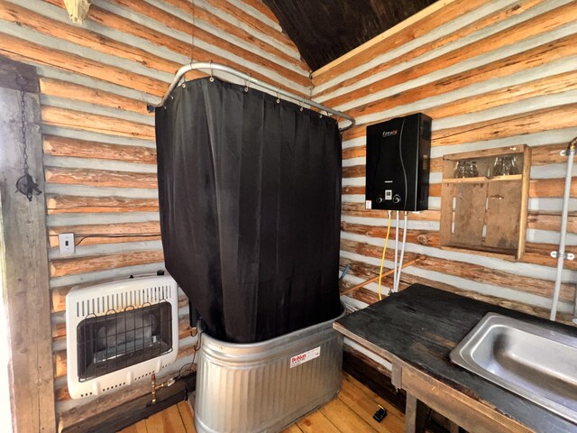 miscellaneous room featuring light hardwood / wood-style floors, heating unit, and rustic walls