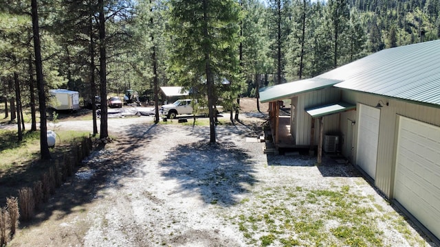 view of street featuring driveway and a forest view