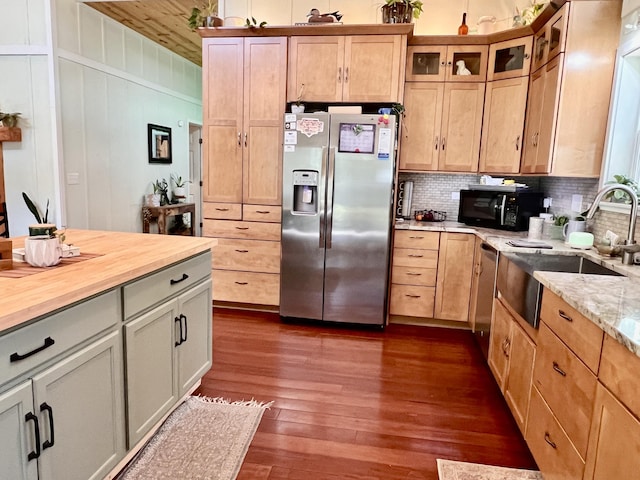 kitchen with dark wood-style floors, stainless steel appliances, decorative backsplash, and a sink
