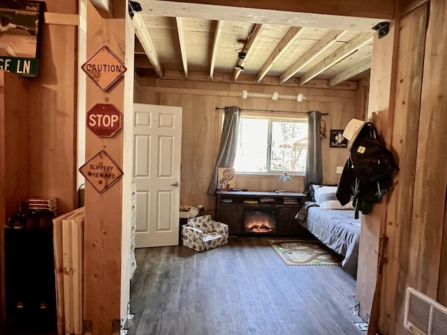 sitting room with wood ceiling, beam ceiling, visible vents, wood walls, and dark wood-type flooring