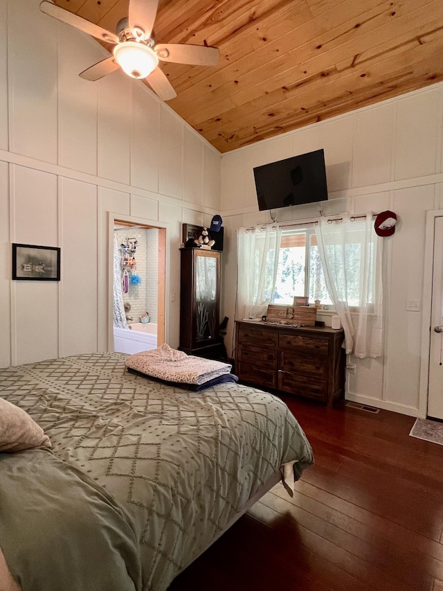 bedroom with a decorative wall, high vaulted ceiling, dark wood finished floors, ceiling fan, and wood ceiling