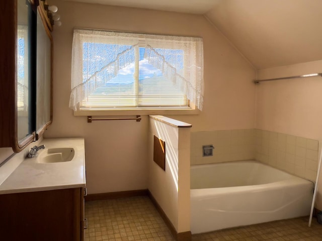 bathroom featuring a bath, lofted ceiling, and vanity