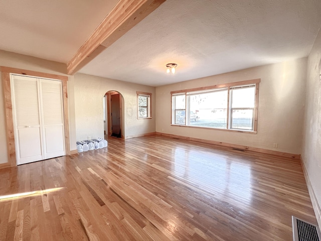 unfurnished bedroom with a closet, light hardwood / wood-style floors, and a textured ceiling