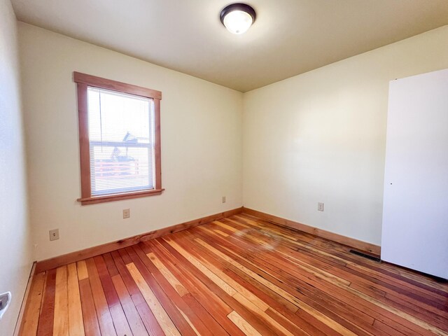 unfurnished room with hardwood / wood-style flooring