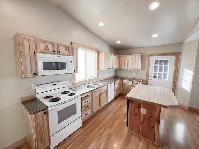 kitchen with wood counters, light brown cabinetry, sink, vaulted ceiling, and white appliances