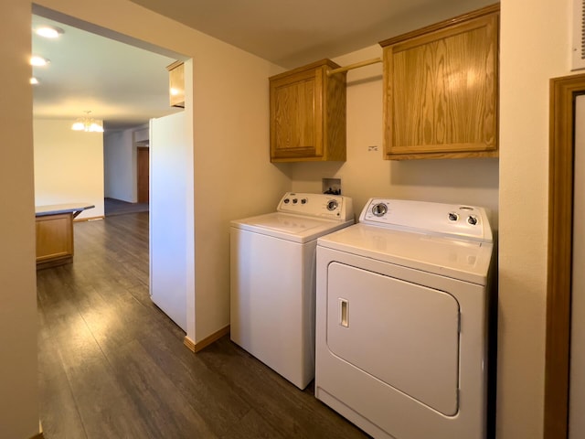 clothes washing area featuring dark wood-style floors, baseboards, cabinet space, and washing machine and clothes dryer