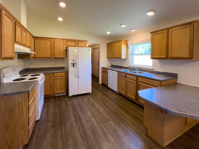 kitchen featuring white appliances, dark countertops, a sink, and under cabinet range hood