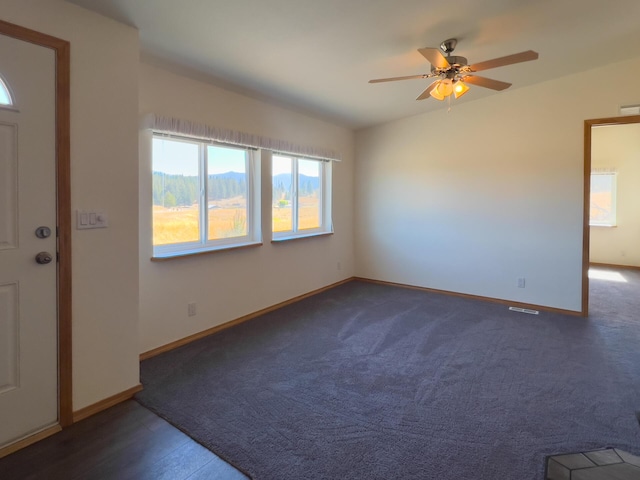 foyer with ceiling fan and baseboards