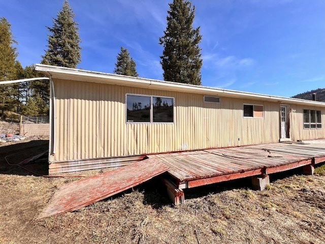 rear view of property featuring a wooden deck