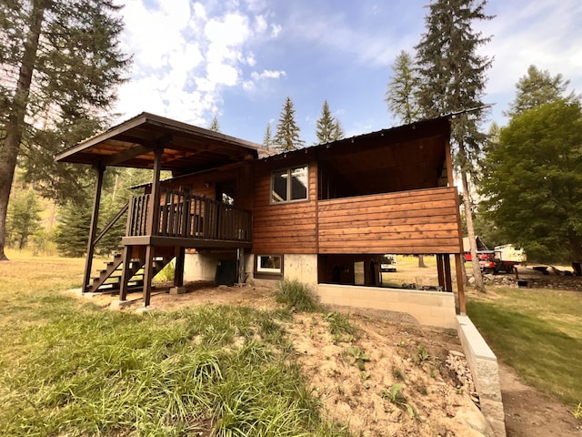 back of house with a deck and a lawn