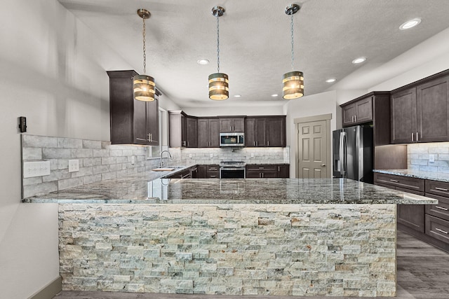 231 Hogans Way, Chewelah, WA 99109 - kitchen with appliances with stainless steel finishes, dark brown cabinetry, decorative backsplash, light stone counters, and a textured ceiling