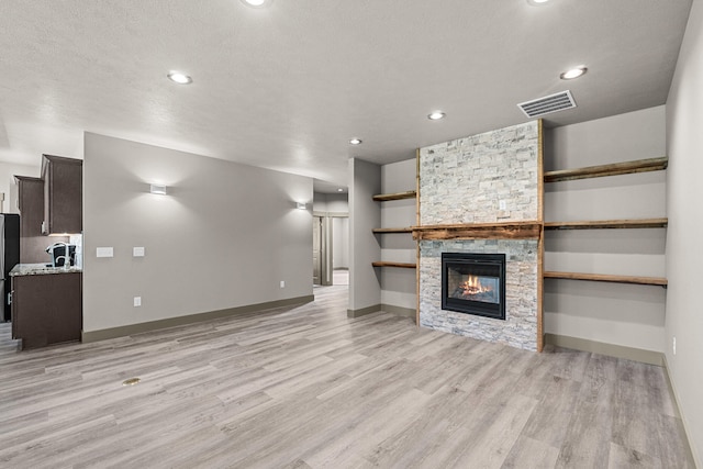231 Hogans Way, Chewelah, WA 99109 - unfurnished living room with light wood-type flooring, a fireplace, and recessed lighting