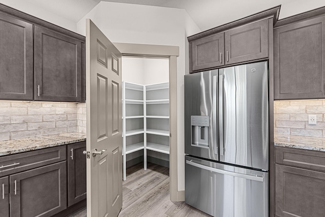 231 Hogans Way, Chewelah, WA 99109 - kitchen featuring stainless steel fridge with ice dispenser, dark brown cabinetry, light wood-style floors, and tasteful backsplash