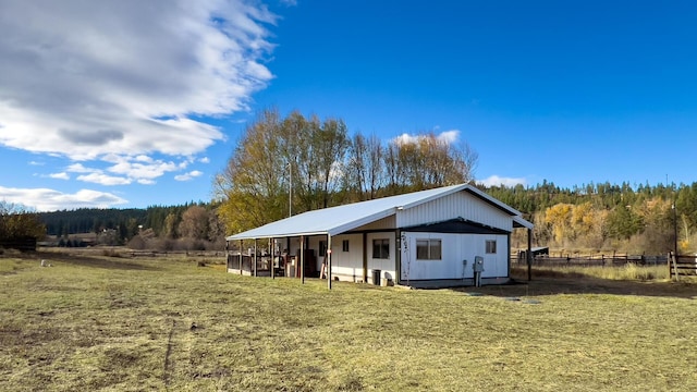 rear view of house with a lawn and a rural view