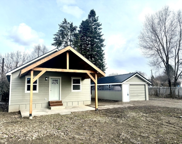 view of front of home with entry steps, an outbuilding, and fence