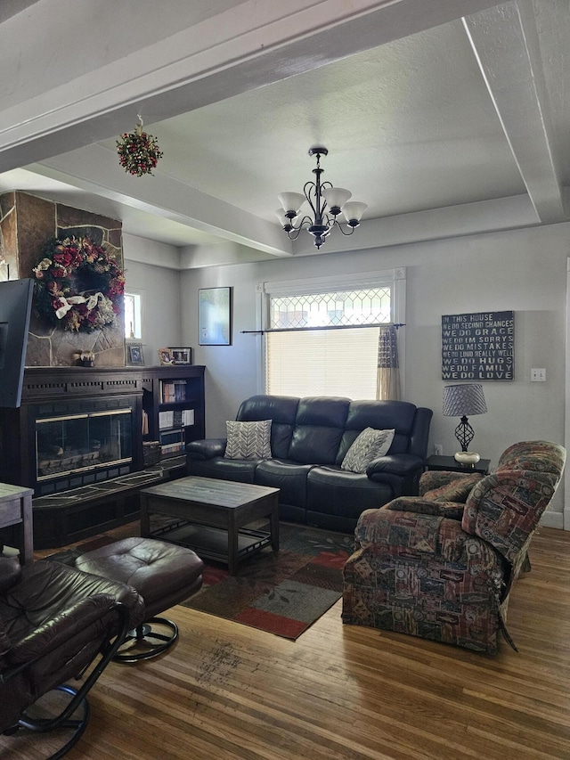 453 E Astor Ave, Colville, WA 99114 - living room with an inviting chandelier, a large fireplace, a healthy amount of sunlight, and wood finished floors