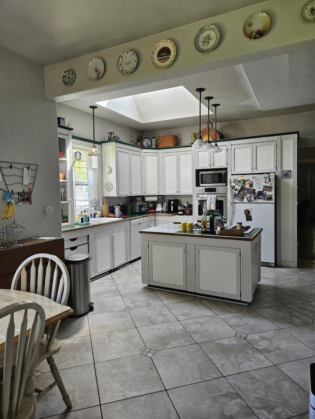 453 E Astor Ave, Colville, WA 99114 - kitchen with a center island, white cabinetry, stainless steel appliances, and decorative light fixtures