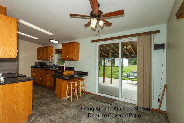 40009 N Sherman Rd, Deer Park, WA 99006 - kitchen featuring a sink, brown cabinets, ceiling fan, a kitchen bar, and a peninsula