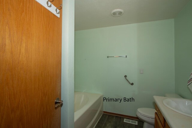 40009 N Sherman Rd, Deer Park, WA 99006 - bathroom featuring vanity, toilet, wood finished floors, a bath, and baseboards
